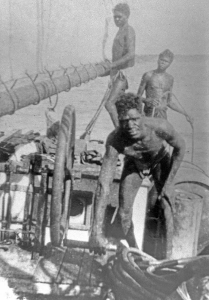 Image of people standing on the deck of a boat. 